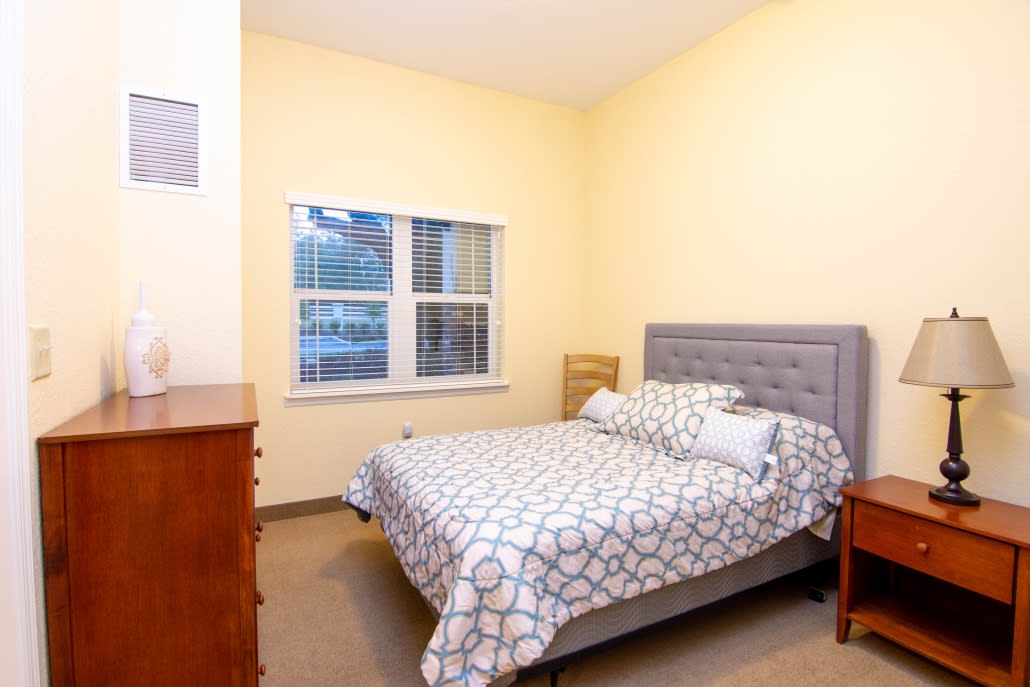 A cozy bedroom with a neatly made bed and soft lighting.