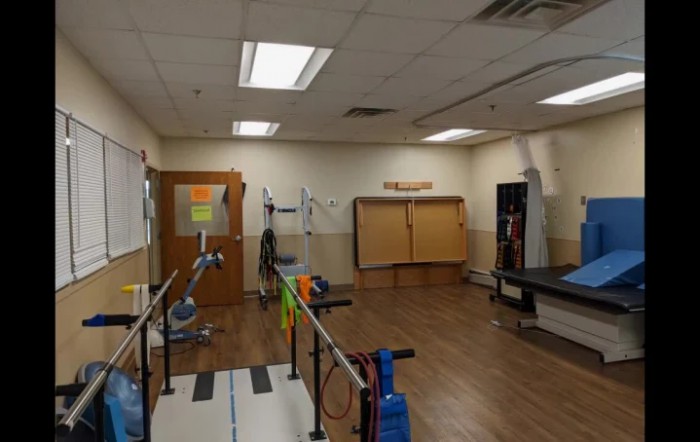 A spacious physical therapy room equipped with various exercise and rehabilitation equipment.