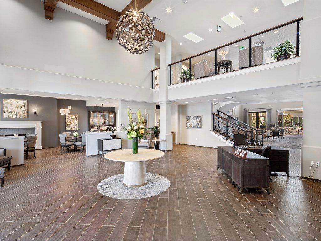 A spacious and modern lobby with elegant furnishings and a striking chandelier.