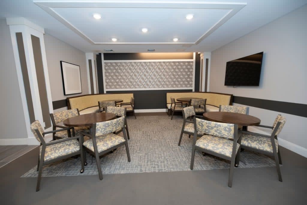 A modern dining area with neatly arranged tables and chairs, featuring elegant interior design.