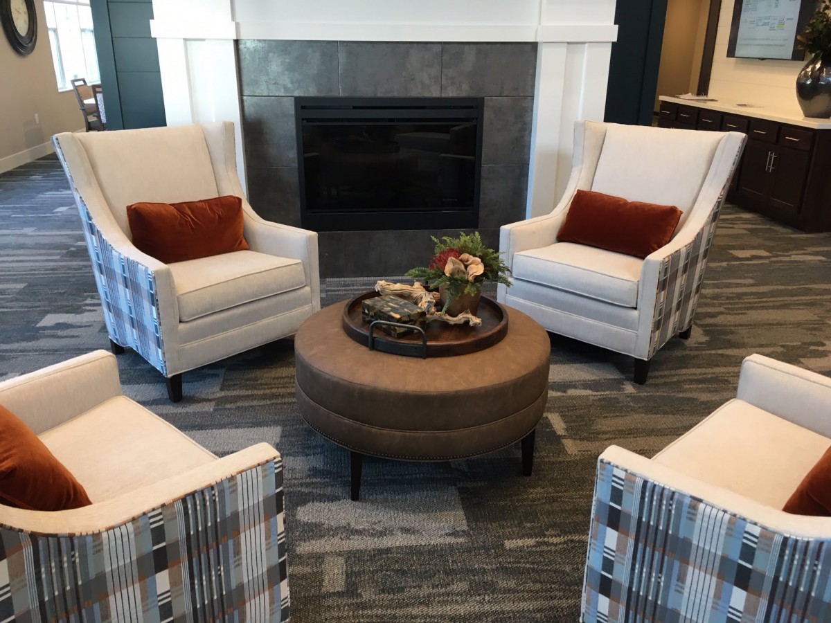 A cozy living room setup with armchairs, a central coffee table, and a fireplace.