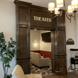 Entrance to a cozy home theater with plush seating and elegant lighting.