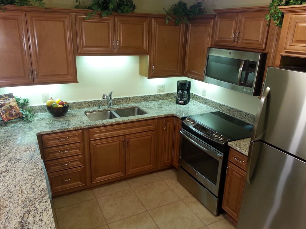 A modern kitchen with wooden cabinets and stainless steel appliances.