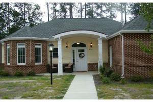 Front view of a brick residential house with a small porch.