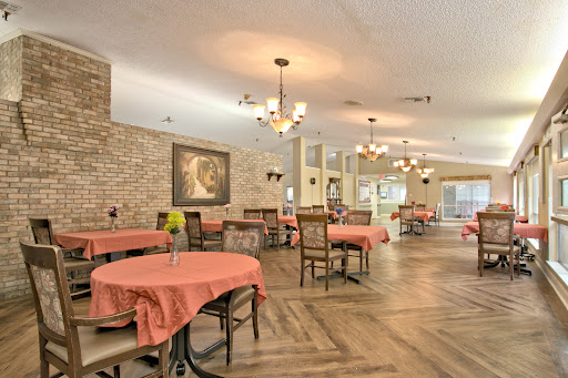A cozy dining area featuring elegant chandeliers and warm brick accents, perfect for gatherings.