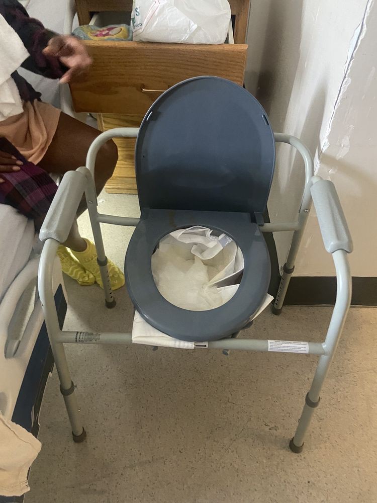 A portable commode chair in a healthcare setting.