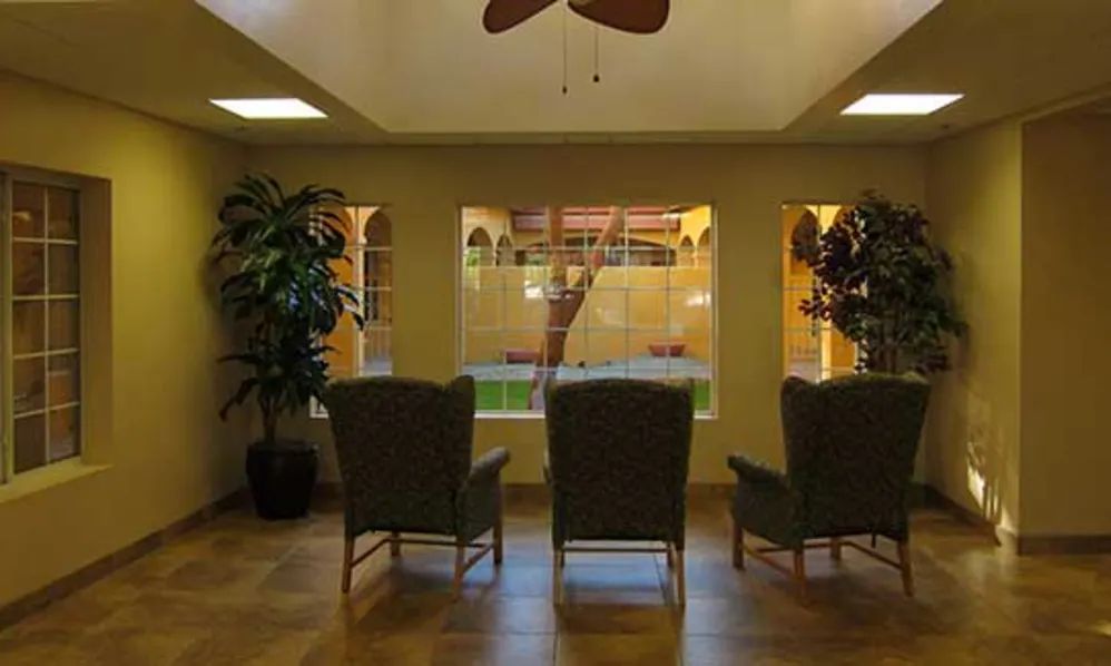 A cozy waiting area with chairs facing a large window overlooking a courtyard.