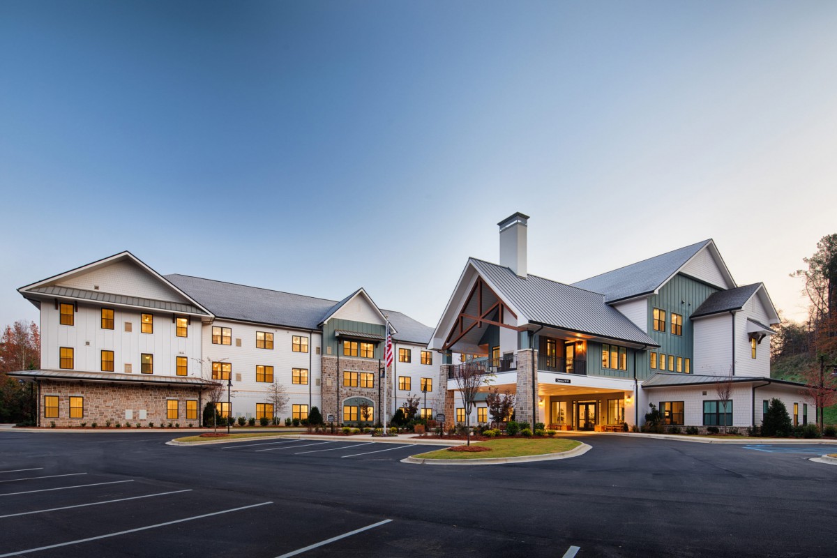 A modern building with a pitched roof design, taken during the evening.