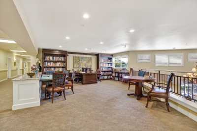 A spacious office library with bookshelves, desks, and chairs.