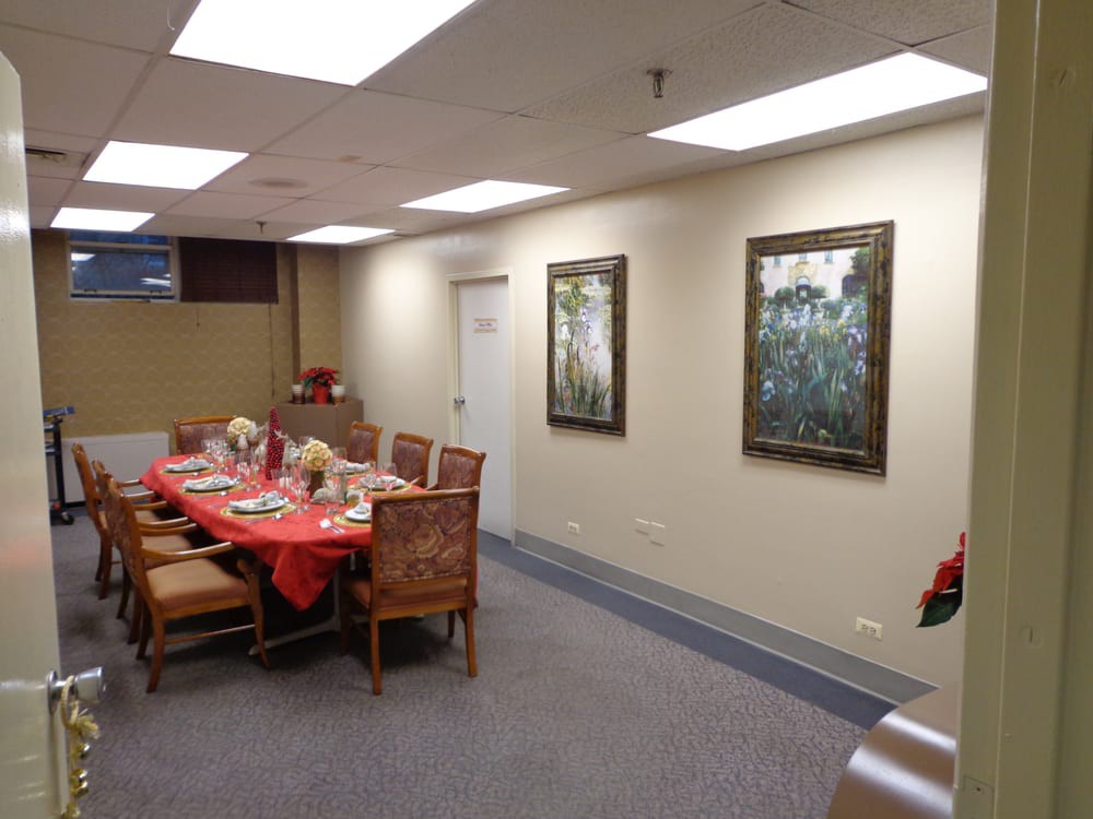 A conference room featuring a dining table set with decorations and surrounded by chairs, with framed artwork on the walls.