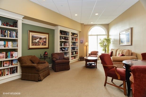 A cozy living room with comfortable seating, a bookshelf, and natural lighting.