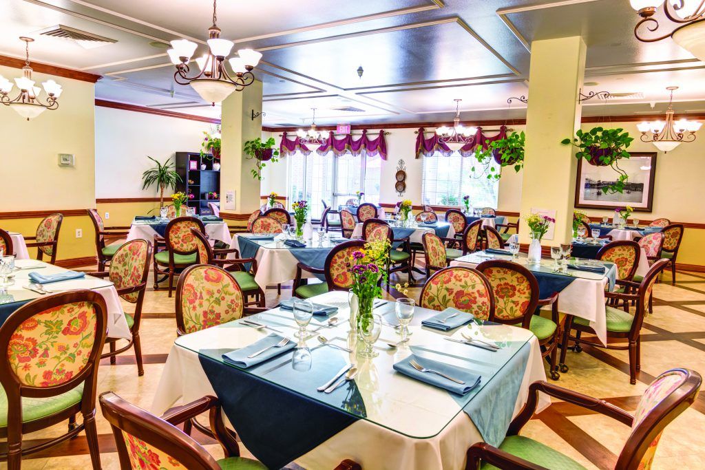 An elegant restaurant dining room with beautifully set tables and floral decor.
