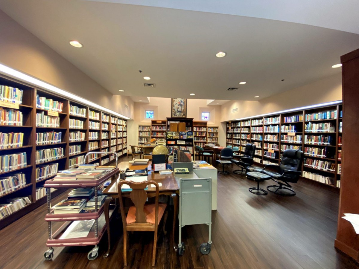 A spacious library with rows of bookshelves and a cozy reading area.