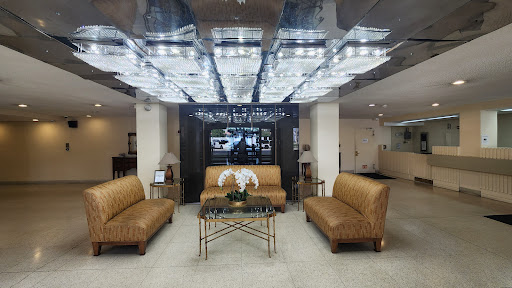 A contemporary lobby featuring stylish leather sofas, modern decor, and elegant lighting.