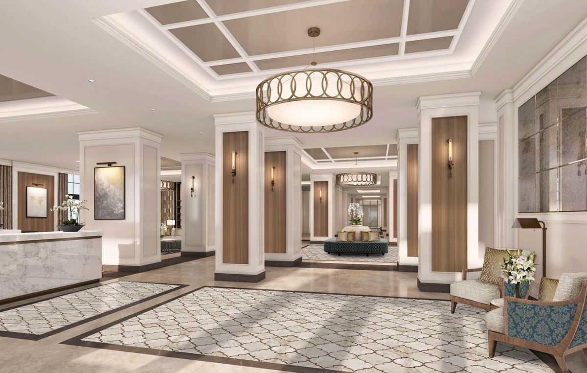 A luxurious hotel lobby featuring elegant interior design with chandeliers and sophisticated flooring.
