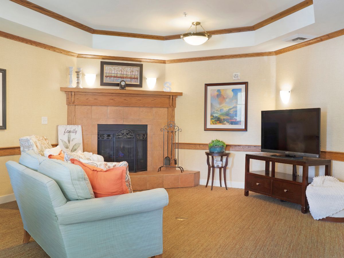 A cozy living room featuring a fireplace, comfortable sofa, and a television.