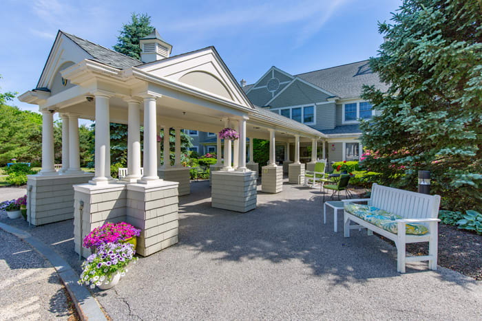 A well-maintained building entrance surrounded by landscaping and colorful flowers.