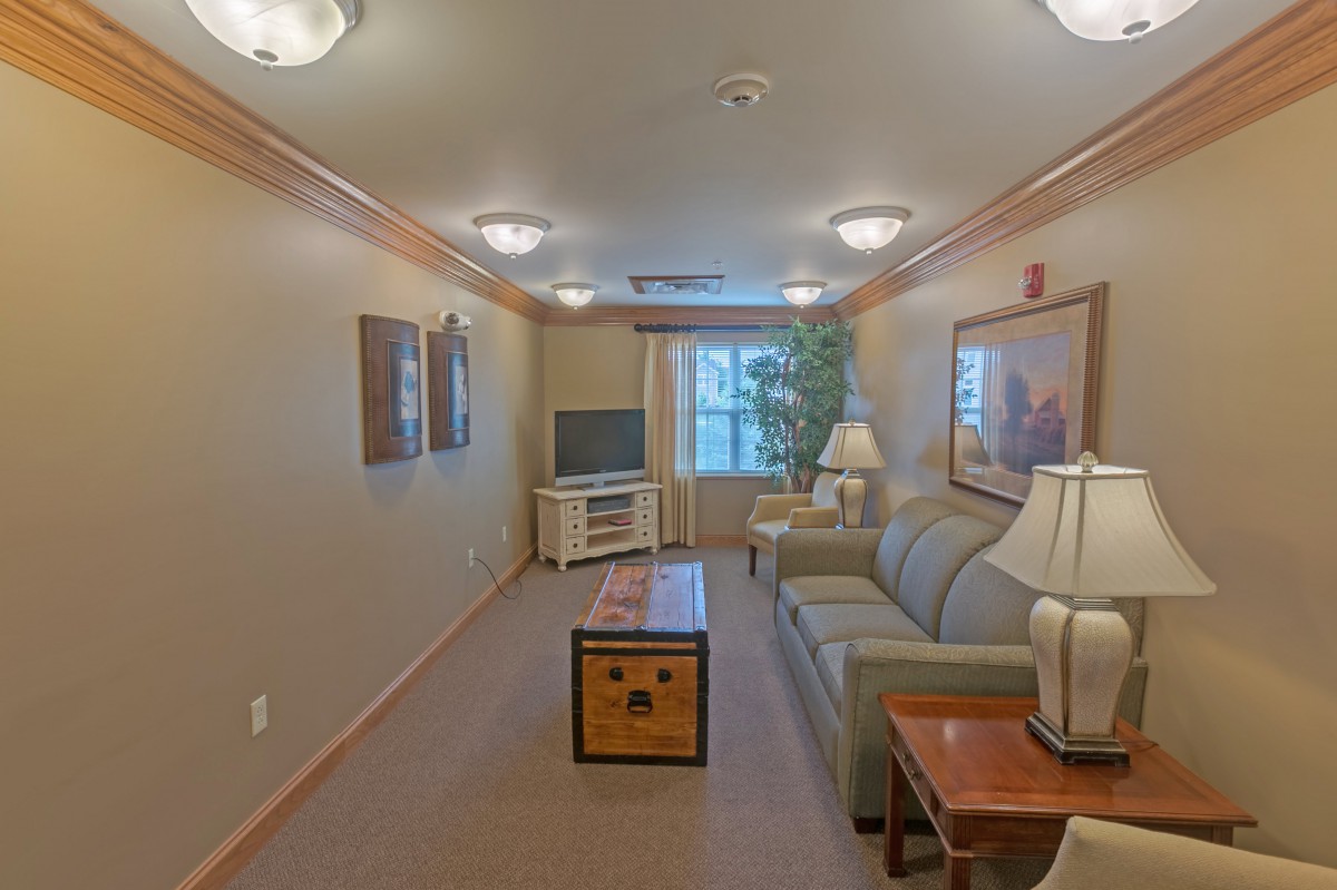A cozy living room with a sofa, coffee table, and TV setup.