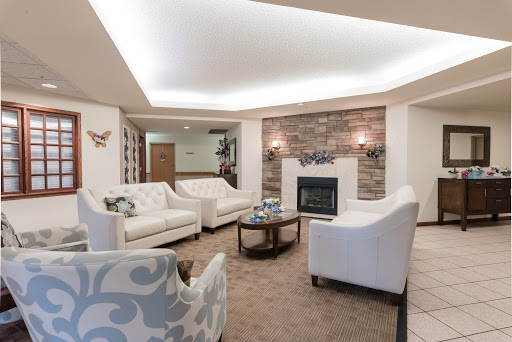 A stylish and cozy living room featuring white furniture, a warm fireplace, and modern decor.