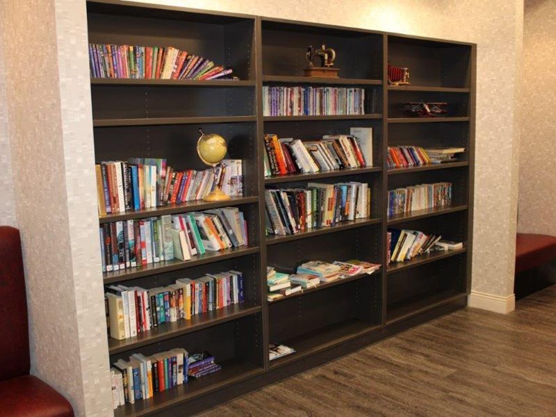 A well-stocked bookshelf filled with a variety of books.