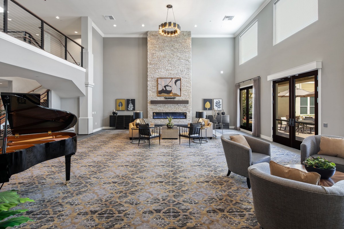 Spacious modern lounge with a grand piano and fireplace.