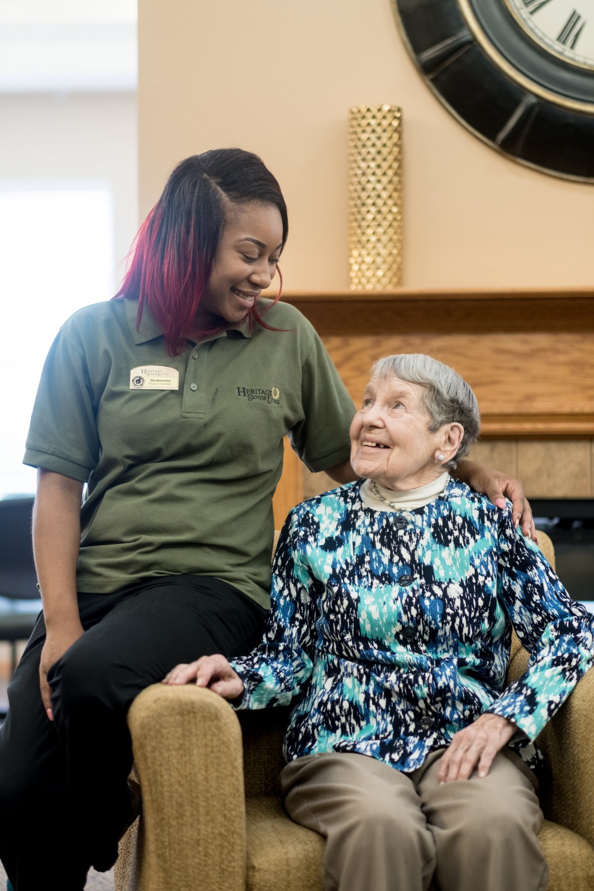 A caregiver and an elderly woman sharing a joyful moment together.