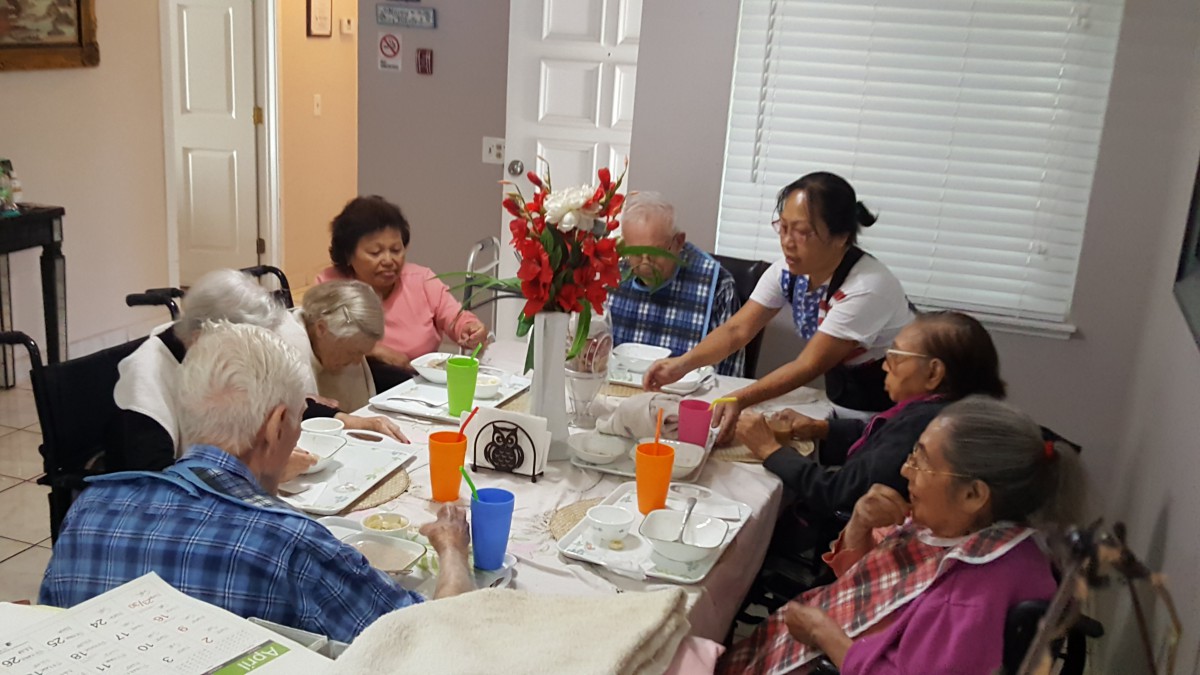 A group of elderly people enjoying a meal together at a dining table.