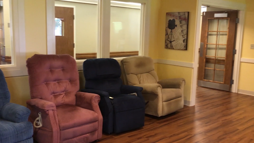 A cozy setup featuring three recliner chairs in a warm-toned room.