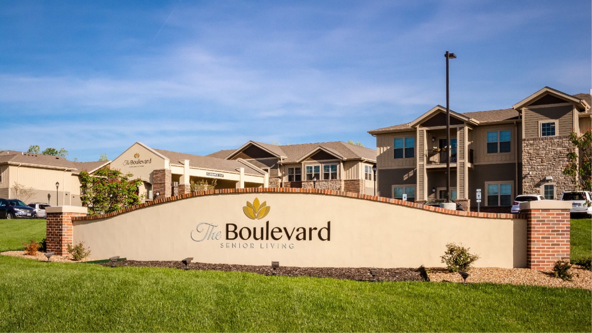 The Boulevard apartment complex entrance with signage and buildings in the background.