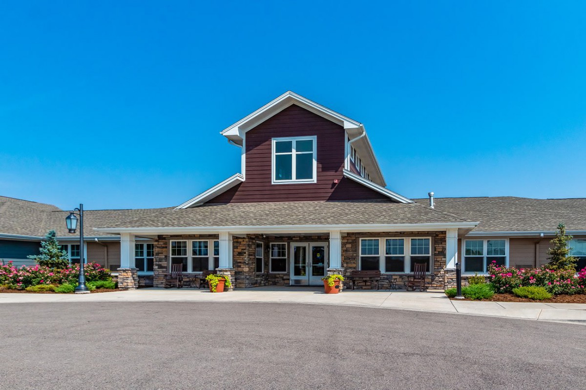A residential building with a welcoming entrance under a clear blue sky.
