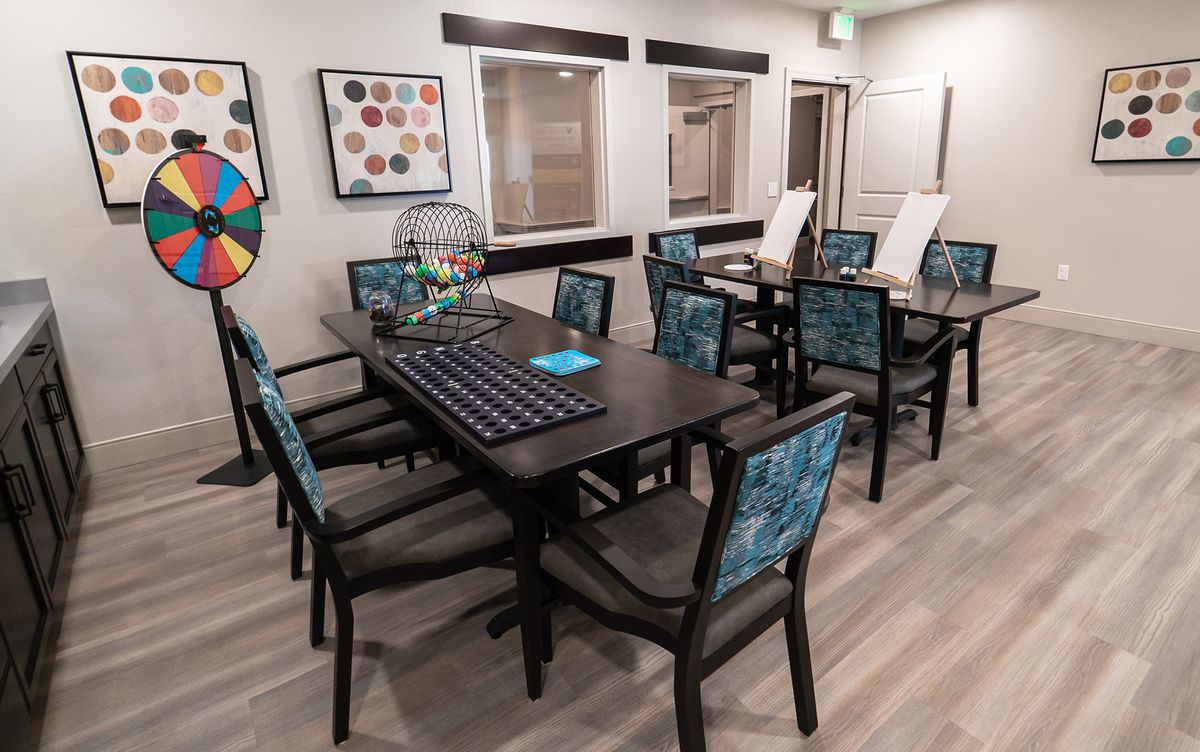 A modern room interior featuring tables and chairs arranged for games, including a bingo setup.