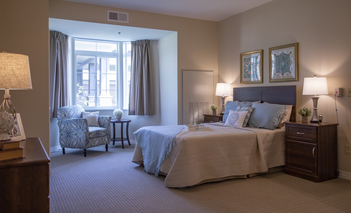 A cozy bedroom with elegant furniture and a large window.