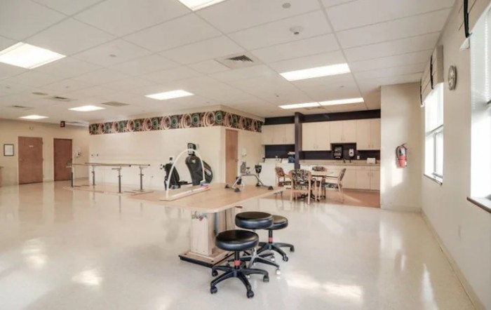 An art classroom with tables, stools, and murals on the walls.