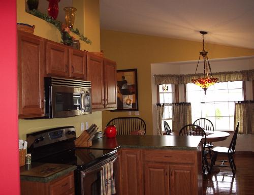 A cozy kitchen featuring wooden cabinets, modern appliances, and a welcoming dining area.