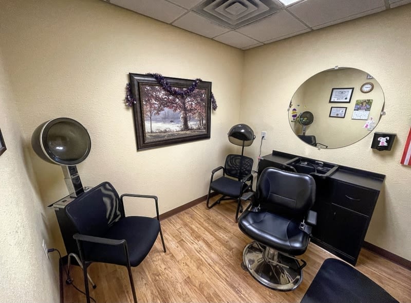 A cozy hair salon room with styling chairs, a mirror, and decor.