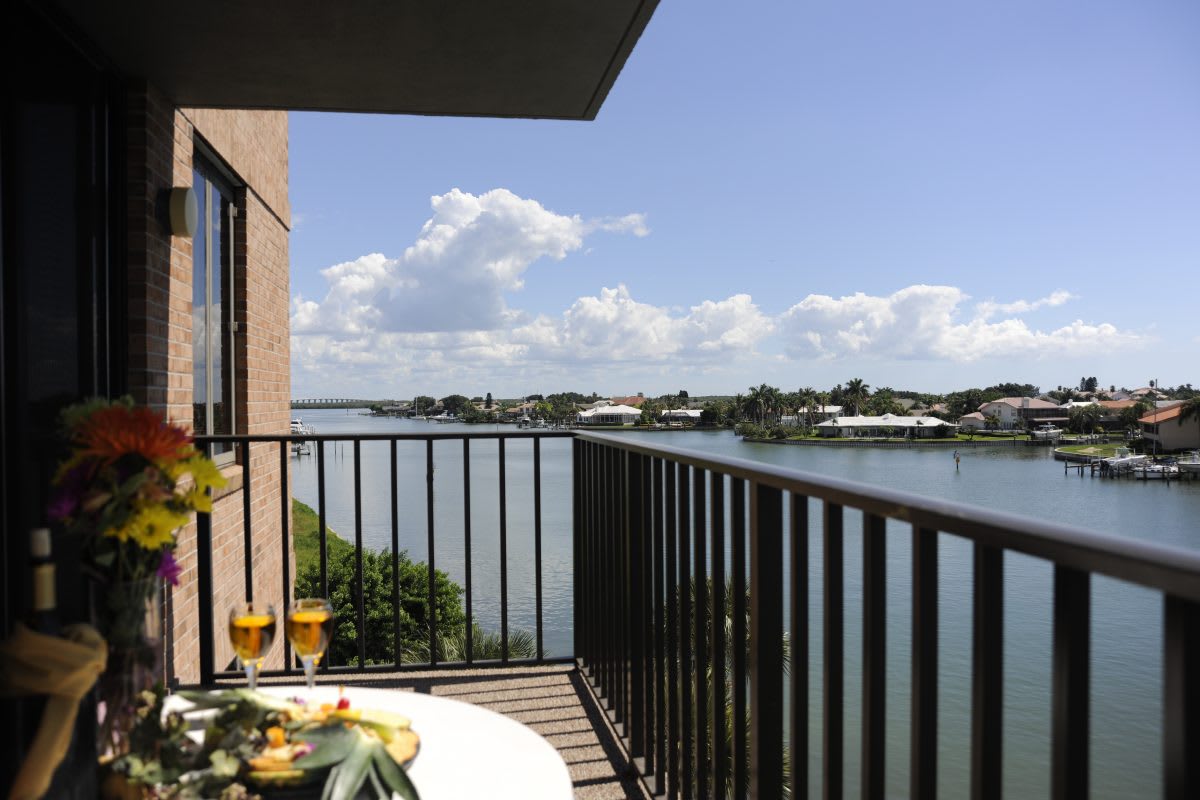 A relaxing balcony with a scenic river view and outdoor dining setup.