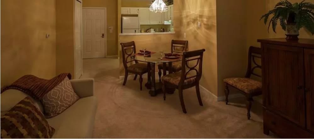 A cozy dining area with a two-chair table set adjacent to an open kitchen.