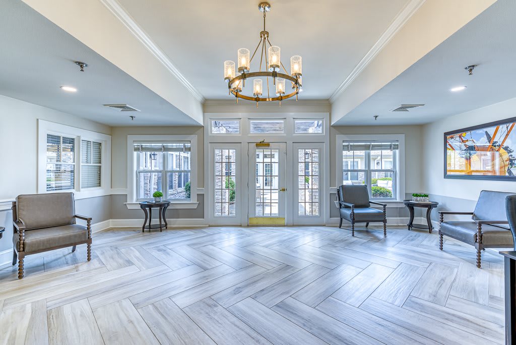 A spacious living room with elegant lighting and expansive windows letting in natural light.