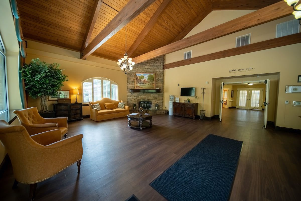A spacious and cozy living room featuring wooden ceilings and comfortable seating.