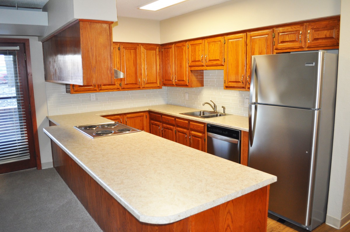 A modern kitchen with wooden cabinets and stainless steel appliances.
