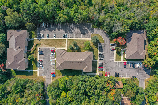 Aerial view of a suburban parking lot surrounded by greenery.