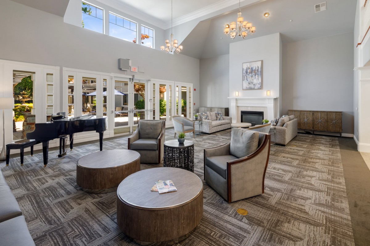 A luxurious living room with modern furnishings, featuring a cozy fireplace and elegant chandeliers.