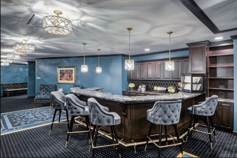 A luxurious home bar featuring modern design with blue walls and comfortable seating.