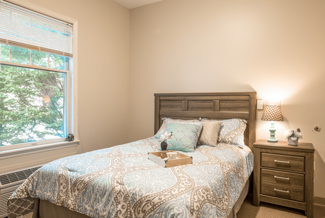 A cozy bedroom with a neatly made bed and soft lighting.