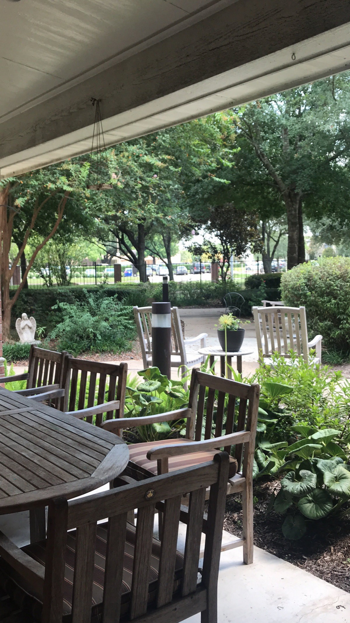 A serene outdoor patio area with wooden chairs and lush greenery.
