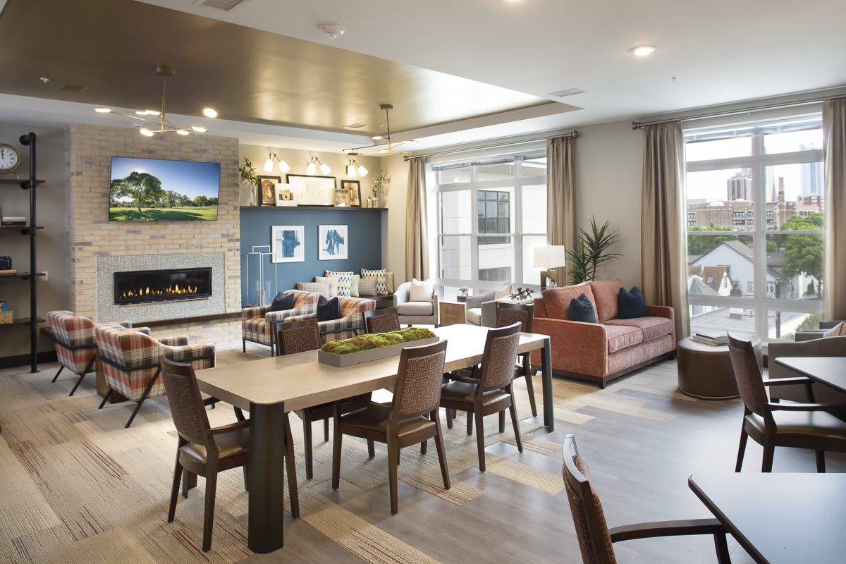 A modern open-concept living and dining area with stylish furniture and a cozy fireplace.
