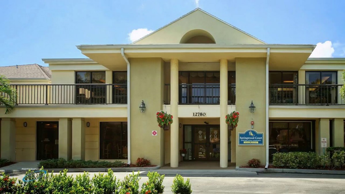A two-story hotel building with a prominent entrance and large columns.