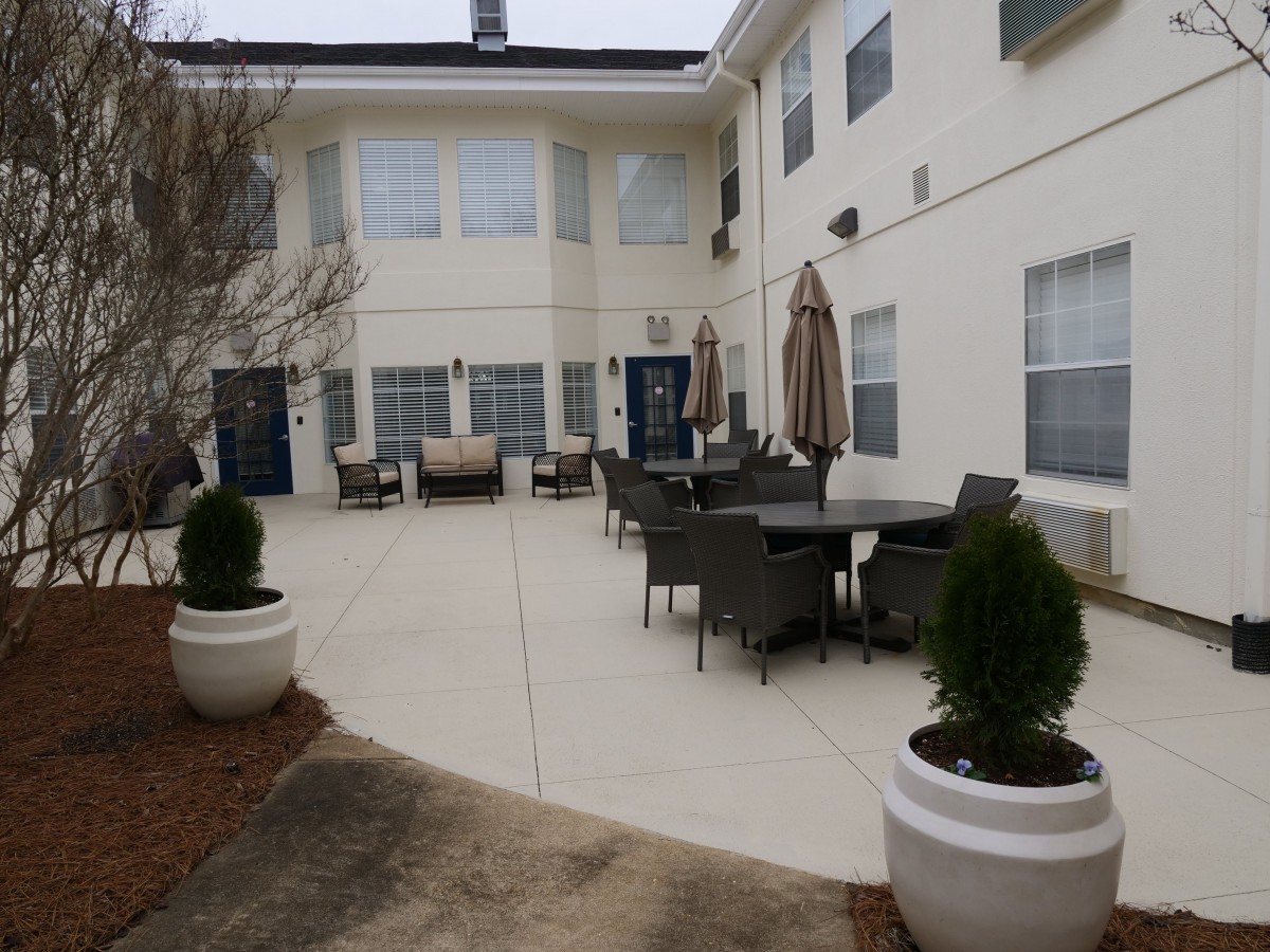 A courtyard with patio furniture and potted plants outside a building.