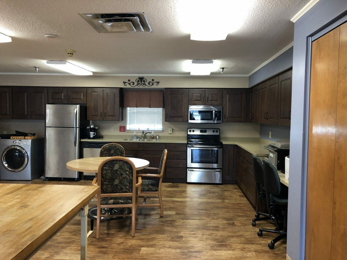 A spacious kitchen with modern appliances and wooden flooring.