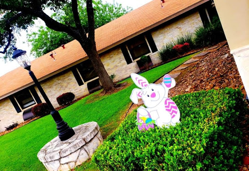 A cheerful Easter bunny decoration in a vibrant yard setting.